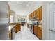 Well-lit kitchen with tile floors, stainless steel appliances, and granite countertops leading to a dining area at 115 Oak Grove Cir, Lake Mary, FL 32746