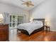 Bedroom with a large window overlooking the lanai, a ceiling fan, and wood floors at 115 Oak Grove Cir, Lake Mary, FL 32746