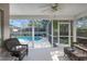 Covered patio with a ceiling fan and outdoor seating, offering a relaxing view of the screened-in pool area at 115 Oak Grove Cir, Lake Mary, FL 32746