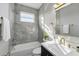 Bathroom with gray marble tile, a shower-tub combo, and updated fixtures at 11508 Delwick Dr, Windermere, FL 34786