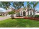Charming home featuring a well-maintained lawn, mature landscaping, and a red tile roof at 11508 Delwick Dr, Windermere, FL 34786