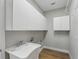 Laundry room featuring white cabinets, a utility sink and wood-look flooring at 11508 Delwick Dr, Windermere, FL 34786