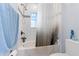 Tiled shower/tub features gray shower curtain, a window, and a hand towel on the wall at 1204 Lexington Ave, Davenport, FL 33837