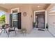 Inviting front porch area with chair and table arrangement, plants, and a view of the home's entryway at 1204 Lexington Ave, Davenport, FL 33837