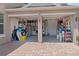 Two car garage packed with storage shelving and bins, with grey epoxy flooring and a brick driveway at 1204 Lexington Ave, Davenport, FL 33837