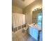 Bathroom features a tub-shower, neutral tile flooring, a single sink vanity, and ample lighting at 1224 S Hiawassee Rd # 638, Orlando, FL 32835