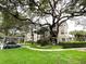Inviting exterior view of a tan-colored building, mature landscaping, a winding walkway, and covered parking at 1224 S Hiawassee Rd # 638, Orlando, FL 32835