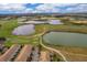 Scenic aerial view of a golf course community featuring multiple ponds and greens at 1227 Sandwedge St, Davenport, FL 33896