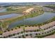 Scenic aerial view of a golf course community with water features bordering residential streets at 1227 Sandwedge St, Davenport, FL 33896