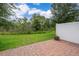 Backyard patio space with brick pavers, green grass, and a privacy fence at 1227 Sandwedge St, Davenport, FL 33896