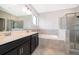 Bathroom showcasing a double sink vanity, soaking tub, and glass enclosed shower at 1227 Sandwedge St, Davenport, FL 33896