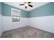 A well-lit bedroom featuring neutral carpet, wainscotting, and a ceiling fan at 1227 Sandwedge St, Davenport, FL 33896