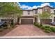 Inviting townhome showcasing a brick-paved driveway and a two-car garage at 1227 Sandwedge St, Davenport, FL 33896