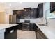 This kitchen boasts dark cabinets, stainless steel appliances, double oven, and quartz countertops at 1227 Sandwedge St, Davenport, FL 33896