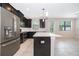 Modern kitchen features stainless steel appliances, dark cabinetry, and a large island with quartz countertop at 1227 Sandwedge St, Davenport, FL 33896