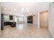 Open-concept living room featuring tile floors, modern fireplace, and black kitchen cabinets at 1227 Sandwedge St, Davenport, FL 33896