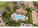 Aerial view of a community pool with a kidney-shaped pool, lounge chairs, palm trees, and a spa at 1227 Sandwedge St, Davenport, FL 33896