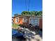 Orange one story home showing windows and electrical components with a partial view of a black car at 1231 Leon Ln, Daytona Beach, FL 32117