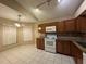 Kitchen with granite counters, brown cabinets and white appliances at 12512 Wisconsin Woods Ln, Orlando, FL 32824