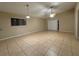 Spacious living room features neutral paint and tile flooring, sliding glass door, and a ceiling fan at 12512 Wisconsin Woods Ln, Orlando, FL 32824