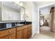 Bathroom with granite counters, wood cabinets, and a door leading to bedroom at 1370 Centre Court Ridge Dr # 204, Reunion, FL 34747