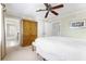 Bedroom features a ceiling fan, ensuite bathroom, and wooden closet for storage at 1370 Centre Court Ridge Dr # 204, Reunion, FL 34747