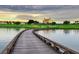 Picturesque golf course view with a wooden bridge over the water towards the building and green grass at 1370 Centre Court Ridge Dr # 204, Reunion, FL 34747