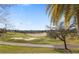 Scenic golf course view with lush green grass, sand traps, palm trees and clear blue sky behind a sidewalk at 1370 Centre Court Ridge Dr # 204, Reunion, FL 34747