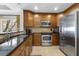 Kitchen features stainless steel appliances, dark granite counters, and wooden cabinets at 1370 Centre Court Ridge Dr # 204, Reunion, FL 34747