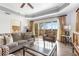 Elegant living room with tray ceiling, hardwood floors, and sliding glass doors to the balcony at 1370 Centre Court Ridge Dr # 204, Reunion, FL 34747