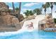 A going down a water slide at the pool with water rushing beneath them and palm trees in the background at 1370 Centre Court Ridge Dr # 204, Reunion, FL 34747