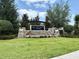 Community entrance sign featuring stone accents, water feature, and lush landscaping at 141 Mitchell Creek Way, Oviedo, FL 32765