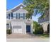 Charming two-story townhome featuring a one-car garage, blue shutters, and a welcoming brick driveway at 141 Mitchell Creek Way, Oviedo, FL 32765