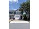Charming two-story townhome featuring a one-car garage, blue shutters, and a welcoming brick driveway at 141 Mitchell Creek Way, Oviedo, FL 32765