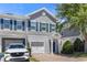Charming two-story townhome featuring gray siding, blue shutters, a brick driveway, and an attached garage at 141 Mitchell Creek Way, Oviedo, FL 32765
