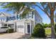 View of a two-story townhome with blue shutters, gray siding, brick driveway, and an attached garage at 141 Mitchell Creek Way, Oviedo, FL 32765