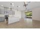 Open-concept kitchen with gray cabinets, stainless steel appliances, a large island, and sliding glass doors at 141 Mitchell Creek Way, Oviedo, FL 32765