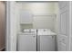 Organized laundry room featuring white front-loading washer and dryer, built-in shelving, and ample storage space at 141 Mitchell Creek Way, Oviedo, FL 32765