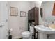 Half bathroom features pedestal sink, toilet, and decorative wall art at 14131 Lakeview Park Rd, Winter Garden, FL 34787