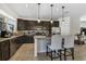 Modern kitchen featuring granite countertops, dark wood cabinets, and stainless steel appliances at 14131 Lakeview Park Rd, Winter Garden, FL 34787