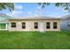 Exterior view of the backyard of this beautiful home showing the lawn, windows, and door at 14208 Morning Frost Dr, Orlando, FL 32828