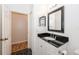 Clean bathroom with black granite countertop and views to a connecting room with wood floors at 14208 Morning Frost Dr, Orlando, FL 32828