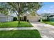 Inviting home featuring a well maintained front lawn, mature landscaping, and a two-car garage for enhanced curb appeal at 14208 Morning Frost Dr, Orlando, FL 32828