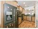 Well-lit kitchen with stainless steel appliances, wood cabinets, granite counters, and wood-look flooring at 14208 Morning Frost Dr, Orlando, FL 32828