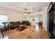 Spacious living room featuring hardwood floors, abundant light, ceiling fan and comfortable leather sofas at 14208 Morning Frost Dr, Orlando, FL 32828