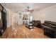 Open-concept living room with hardwood floors, comfortable seating, view of kitchen pass-through, and a ceiling fan at 14208 Morning Frost Dr, Orlando, FL 32828