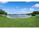 Scenic view of the community pond with lush green lawns, landscaping, and a fountain at 14208 Morning Frost Dr, Orlando, FL 32828