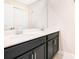 Bathroom with double sink vanity, white countertop and dark cabinetry at 1504 Oak Marsh Loop, Davenport, FL 33837