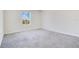 Empty bedroom featuring gray carpet, white walls, and a window at 1504 Oak Marsh Loop, Davenport, FL 33837