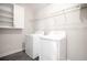 A conveniently located laundry room is equipped with a washer, dryer, storage shelves and cabinet at 1504 Oak Marsh Loop, Davenport, FL 33837